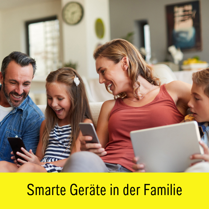 Vater, Tochter, Mutter und Sohn lachend mit Handys und Tablets auf der Couch