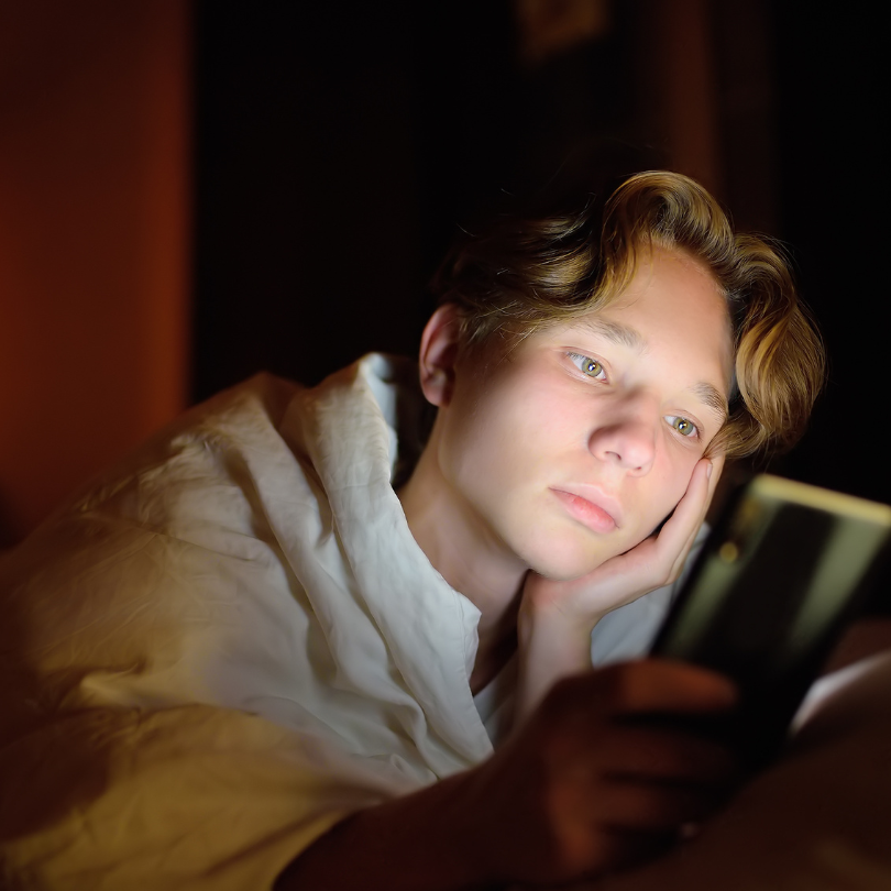 Junge der auf ein Handy blickt